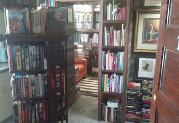Tall wooden shelves packed with paperbacks and hardbacks in the hotel bookstore