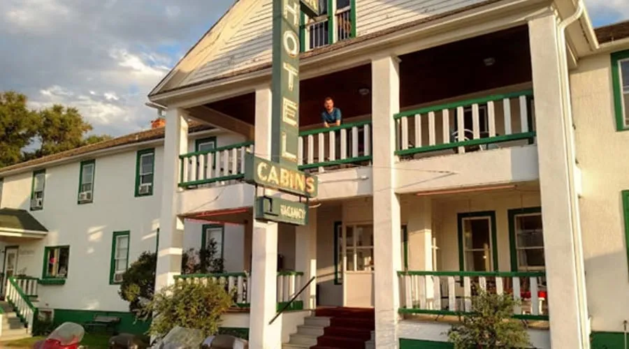 The front of the Kempton Hotel, with its white columns, green balcony rails, red-carpeted steps and neon HOTEL sign