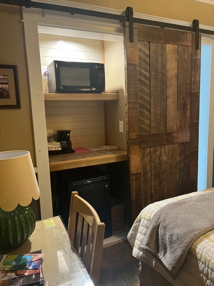 A coffee nook with a microwave and coffee maker beside a sliding barn-wood door