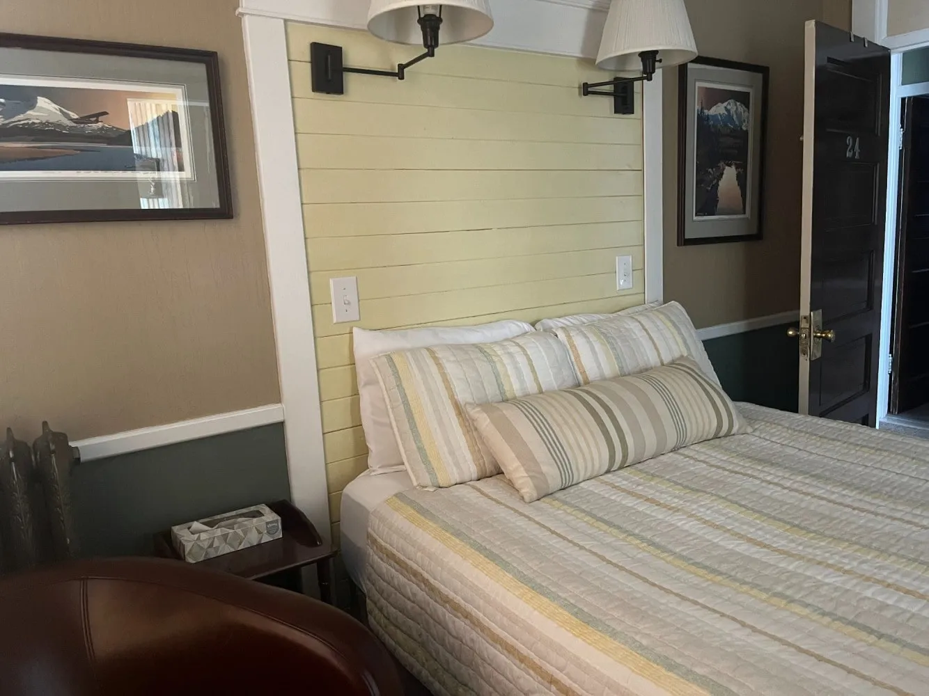 A remodelled deluxe queen room with a pale wood-panelled headboard wall